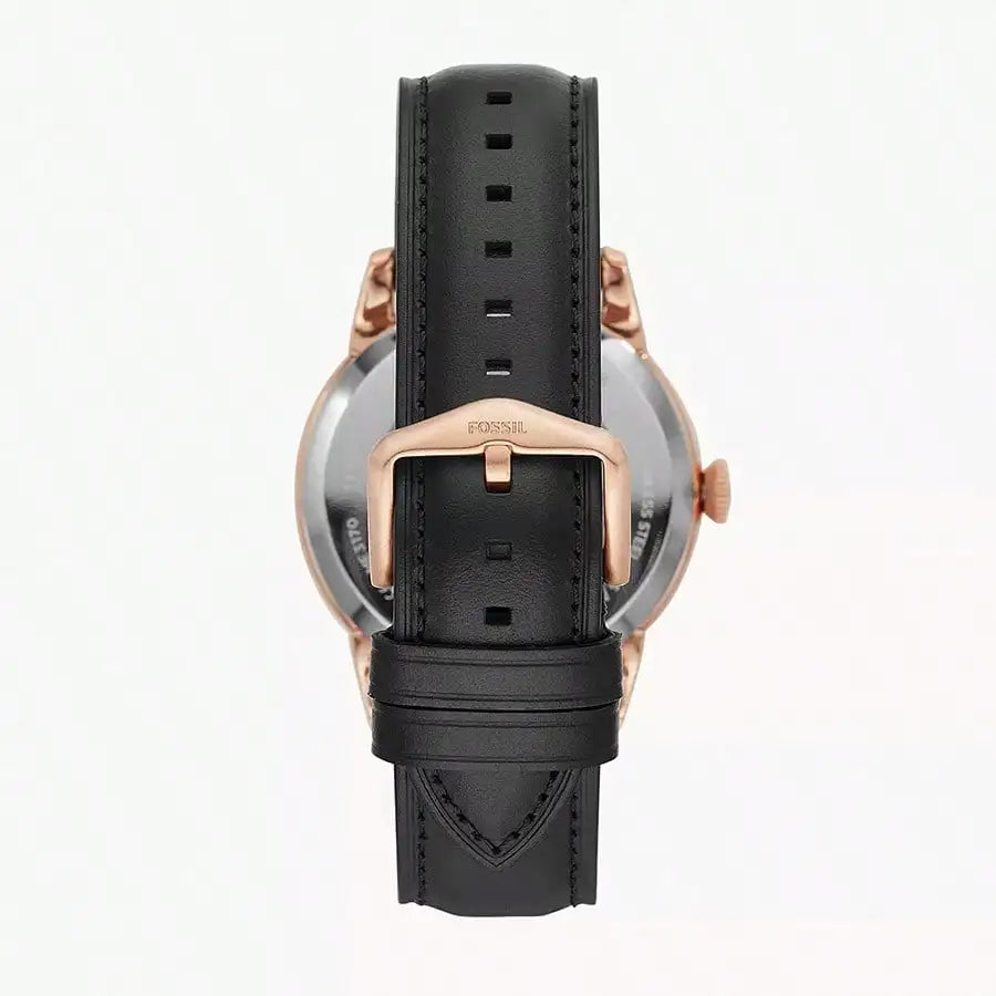 Vista trasera del reloj Fossil ME3265 con correa de cuero negra, hebilla y caja en oro rosado, detalles visibles y centrados.