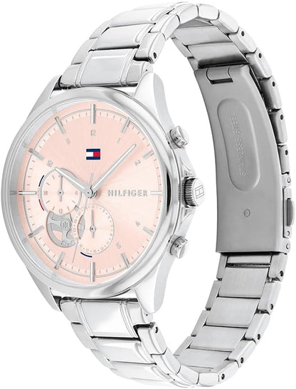 Reloj Tommy Hilfiger de mujer con esfera rosa y brazalete de acero visto en ángulo inclinado.