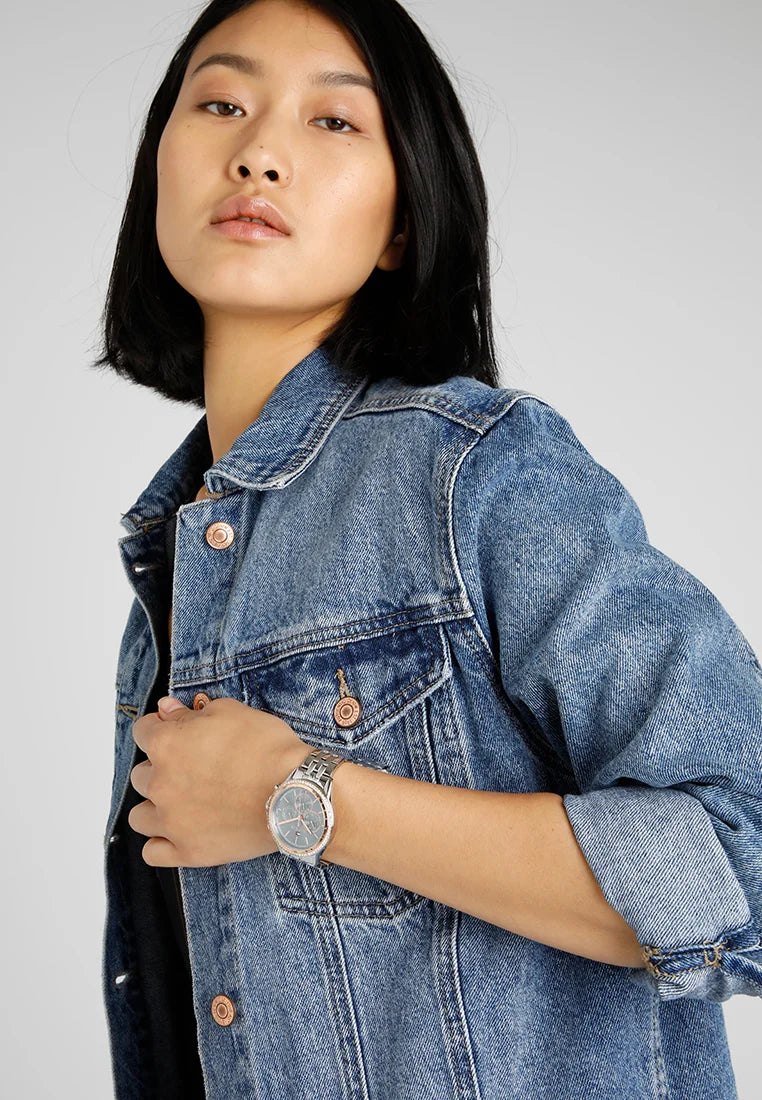 Reloj Tommy Hilfiger para mujer con brazalete de acero, mostrado en muñeca en un look casual con chaqueta vaquera.