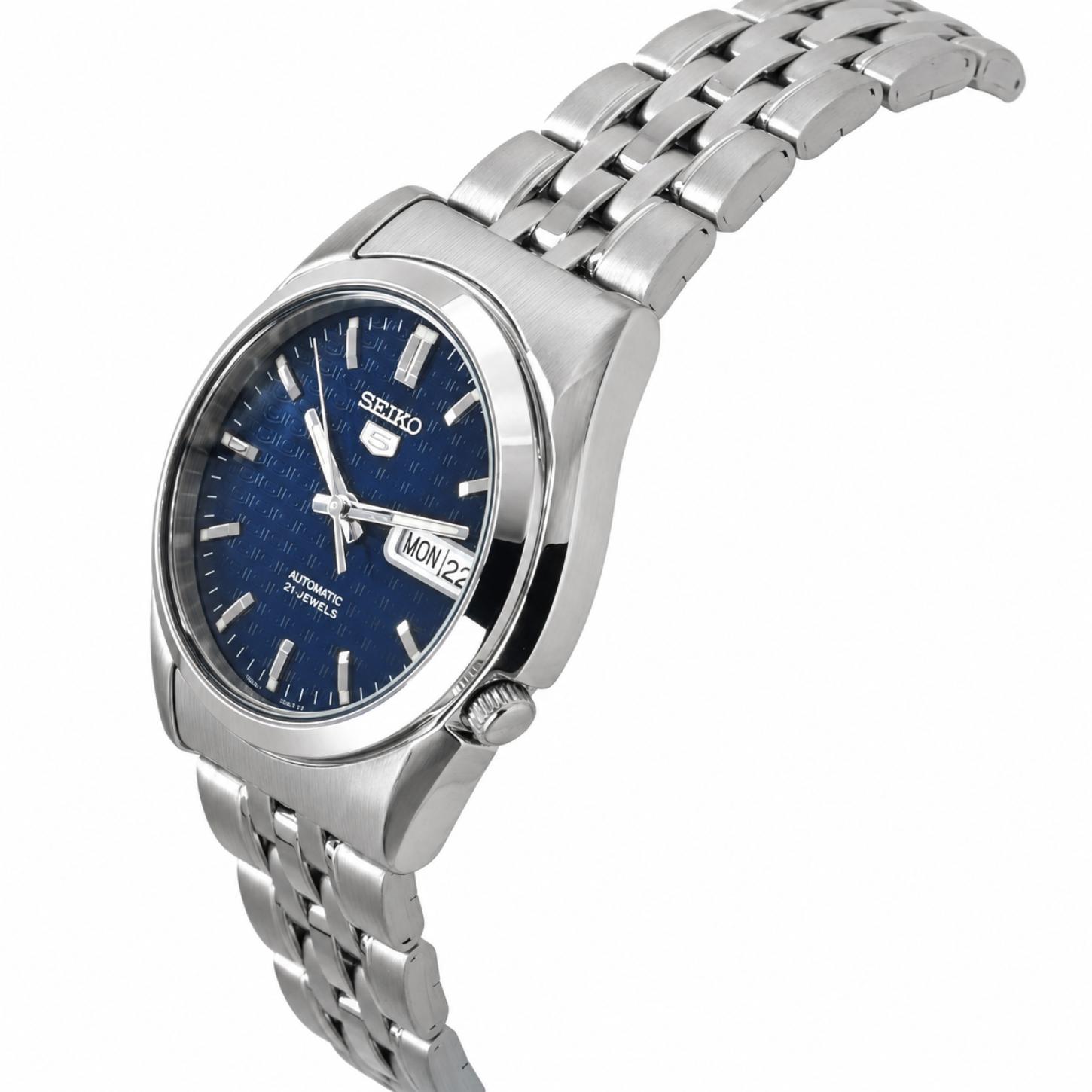 Angled view of the Seiko 5 SNK357K1 automatic watch showing the textured blue dial, day-date display, crown, silver-tone case, and stainless steel bracelet.