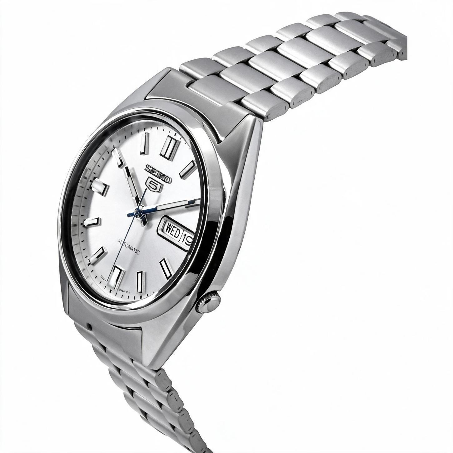 Angled view of the Seiko 5 SNXS73K1 automatic watch showing the silver dial, day-date display, polished case, crown, and stainless steel bracelet.