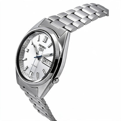 Angled view of the Seiko 5 SNXS73K1 automatic watch showing the silver dial, day-date display, polished case, crown, and stainless steel bracelet.