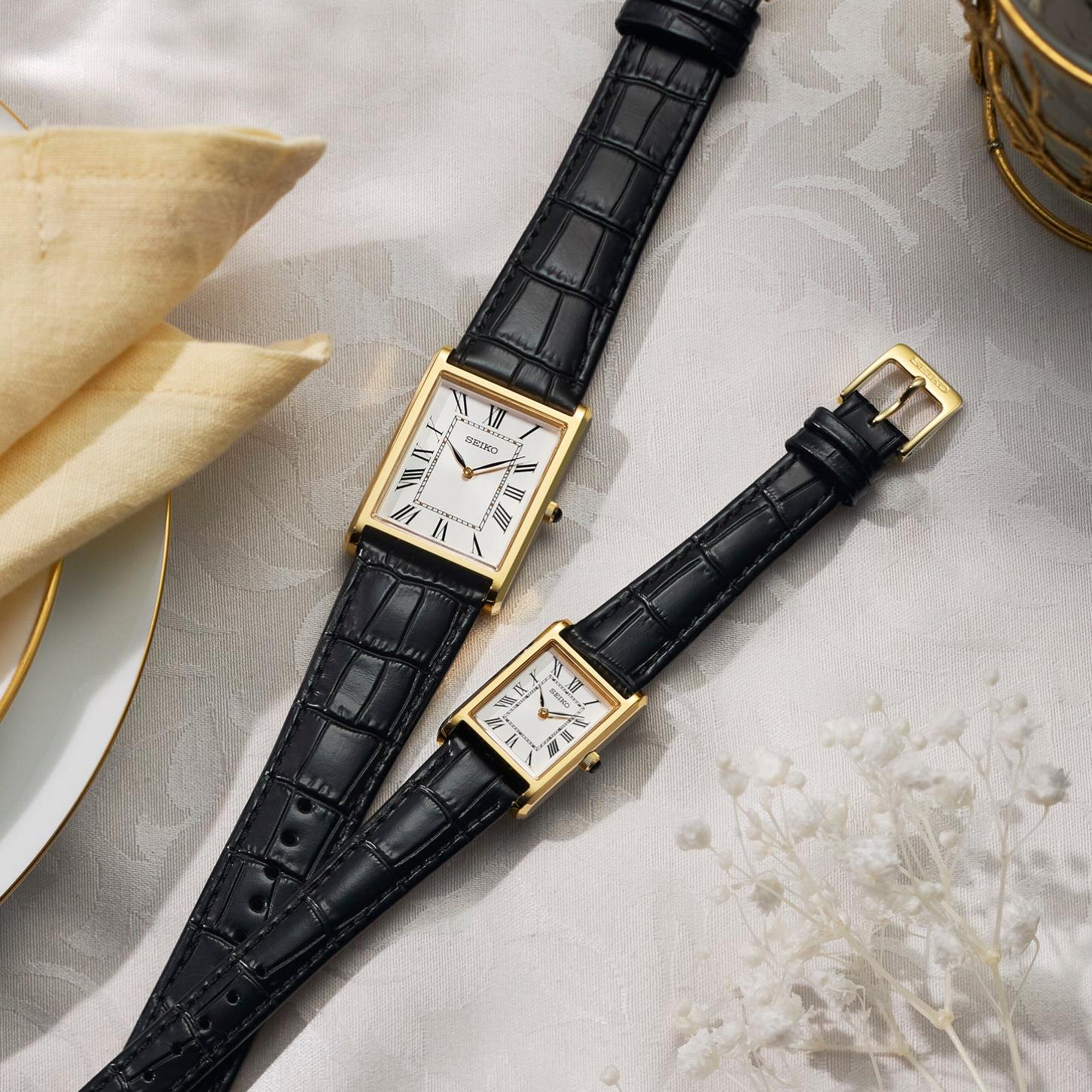 Seiko Classic SWR104P1 rectangular dress watch displayed in an elegant setting with a white Roman numeral dial, gold-tone case, and black leather strap.