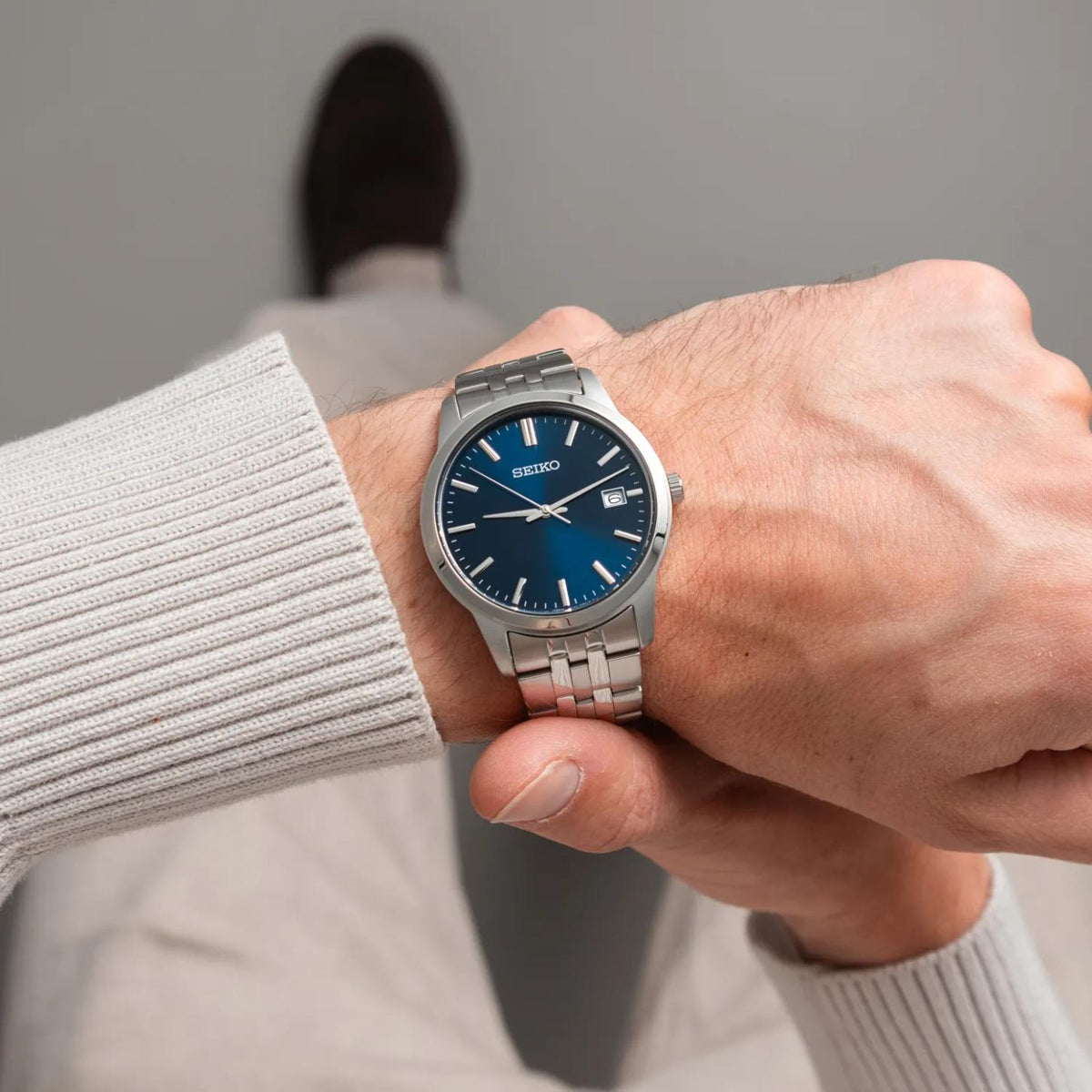 Seiko Essentials SUR399 men's quartz watch worn on wrist with vibrant blue dial and stainless steel bracelet