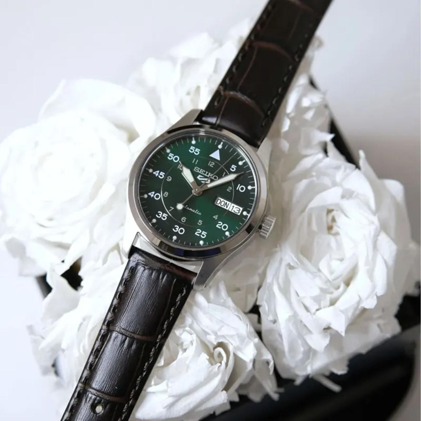 Seiko SRPJ89K1 mens automatic field watch with green dial and brown leather strap displayed on white flowers in lifestyle setting