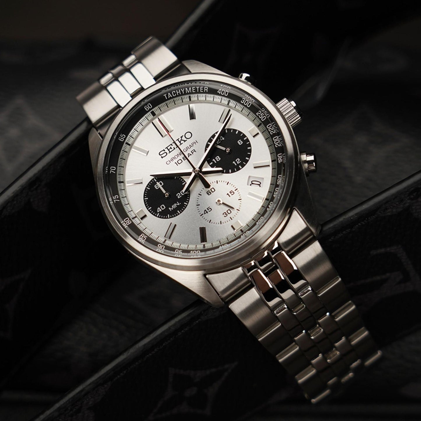Seiko SSB425P1 chronograph watch with white dial, black subdials and stainless steel bracelet shown in lifestyle setting.