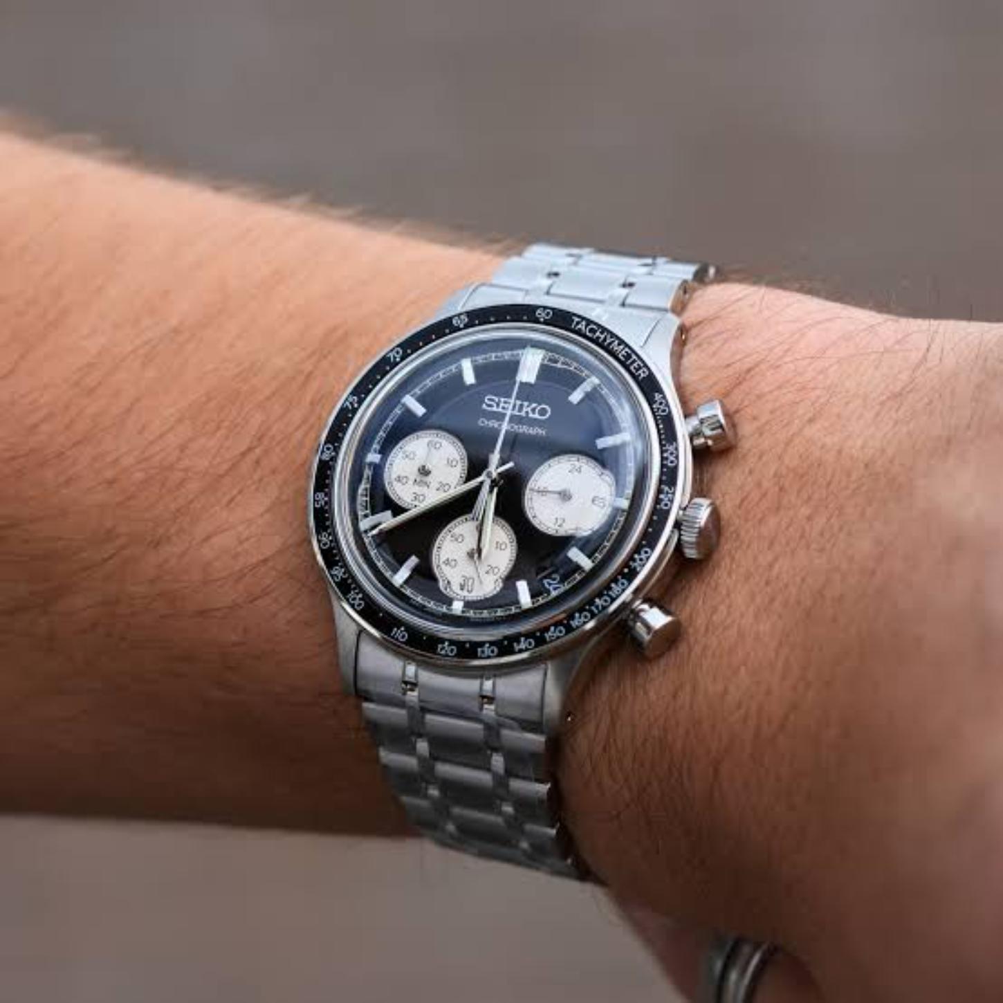 Seiko SSB479P1 sport chronograph worn on the wrist, featuring a black reverse panda dial, three contrasting subdials, tachymeter bezel, and silver-tone bracelet.