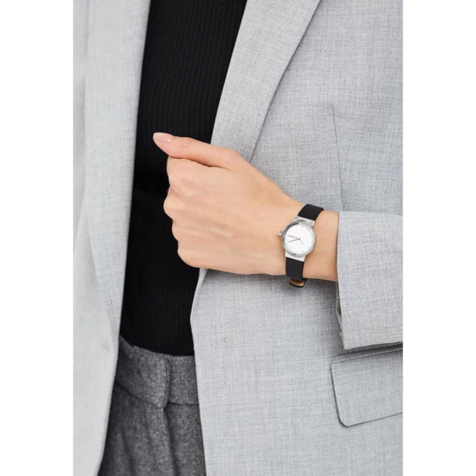 Skagen Freja Lille SKW3119 with silver sunray dial, polished silver-tone case, and black leather strap worn on the wrist in an elegant minimalist style.