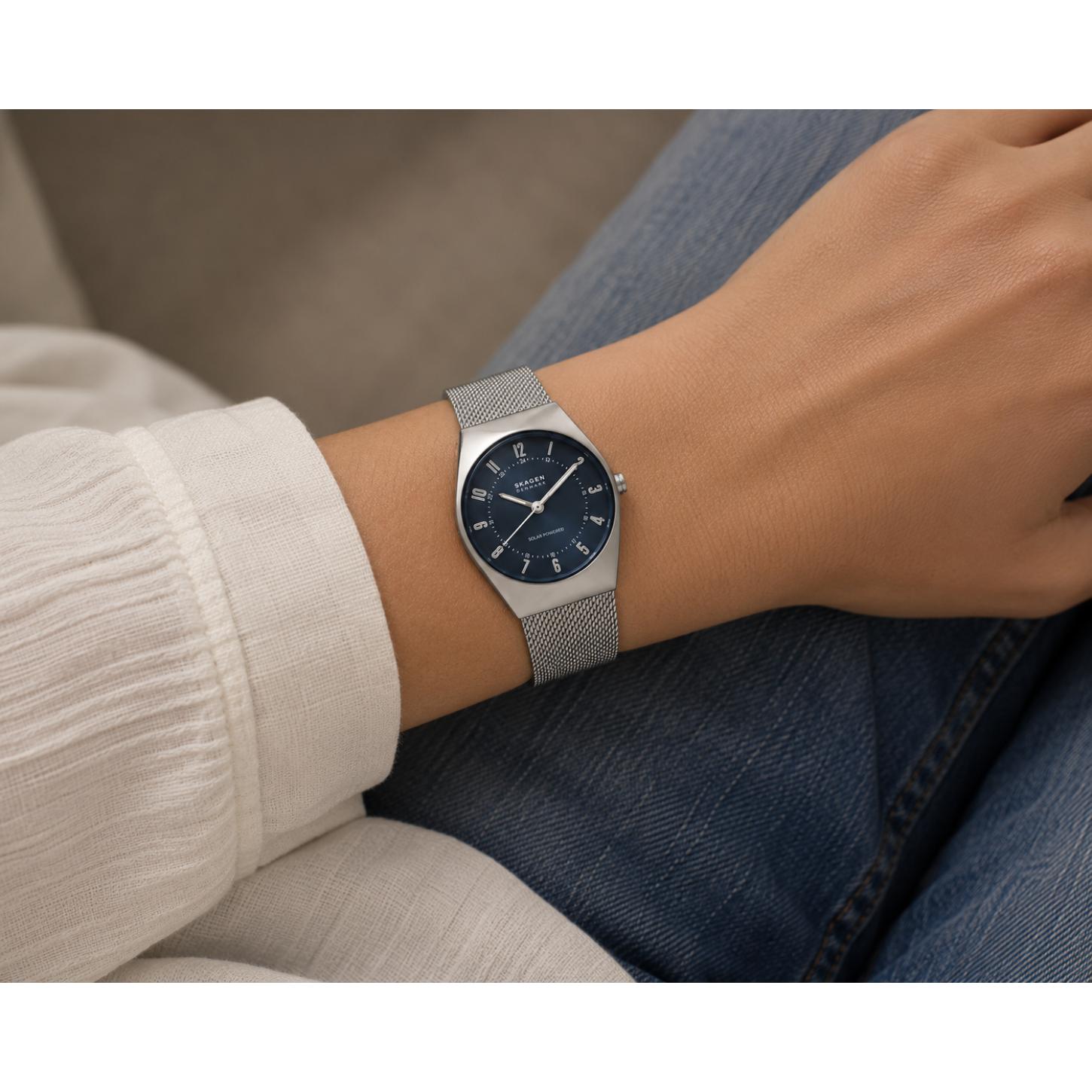 Skagen Grenen Lille Solar SKW3080 worn on the wrist with blue dial, silver-tone case, Arabic numeral markers, solar-powered movement, and stainless steel mesh bracelet.
