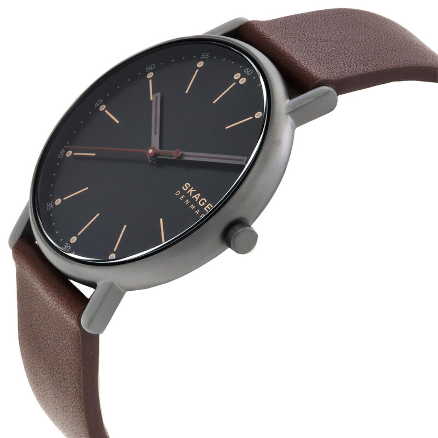 Skagen SKW6860 with black minimalist dial, slim gunmetal-tone case, rose gold-tone markers, and brown leather strap shown in a close-up angled view.
