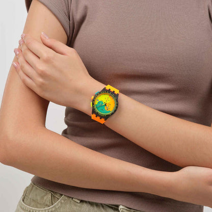 Swatch Neon Signal Flag SUS B422 chronograph watch with a vivid multicolor dial, black case, colorful controls, and bright orange strap worn on the wrist.