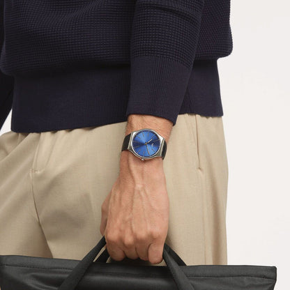 Swatch Skin Irony Formal Blue SS07S125 worn on the wrist with blue sunray dial, slim silver-tone hour markers and hands, polished silver-tone case, and black strap in a smart casual look.