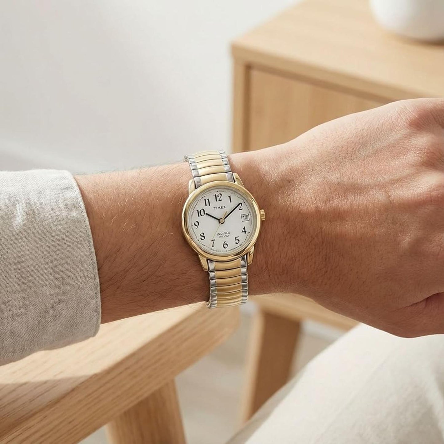 Timex Easy Reader 25mm women’s watch with white dial, gold-tone case, and two-tone expansion bracelet worn on the wrist.