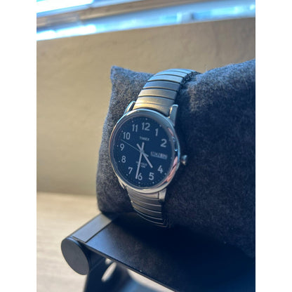 Timex Easy Reader Day Date T20031 men’s watch with blue dial and stainless steel expansion bracelet displayed on a fabric watch cushion.