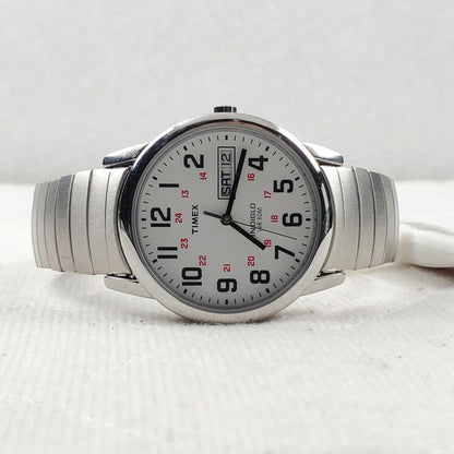 Timex Easy Reader Day Date T20461 men’s watch with white dial, red 24-hour markers, and stainless steel expansion bracelet displayed on a flat surface.