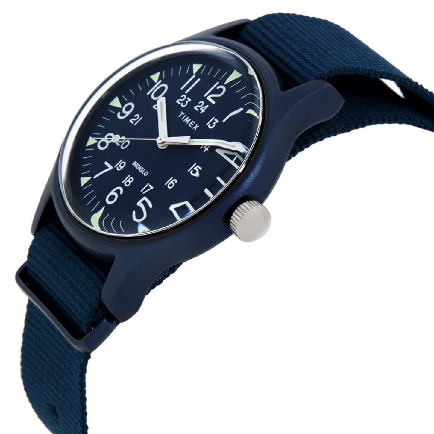 Timex MK1 TW2R37300 from a side angle with a blue dial, white Arabic numerals, blue aluminum case, silver-tone crown, and matching fabric strap.
