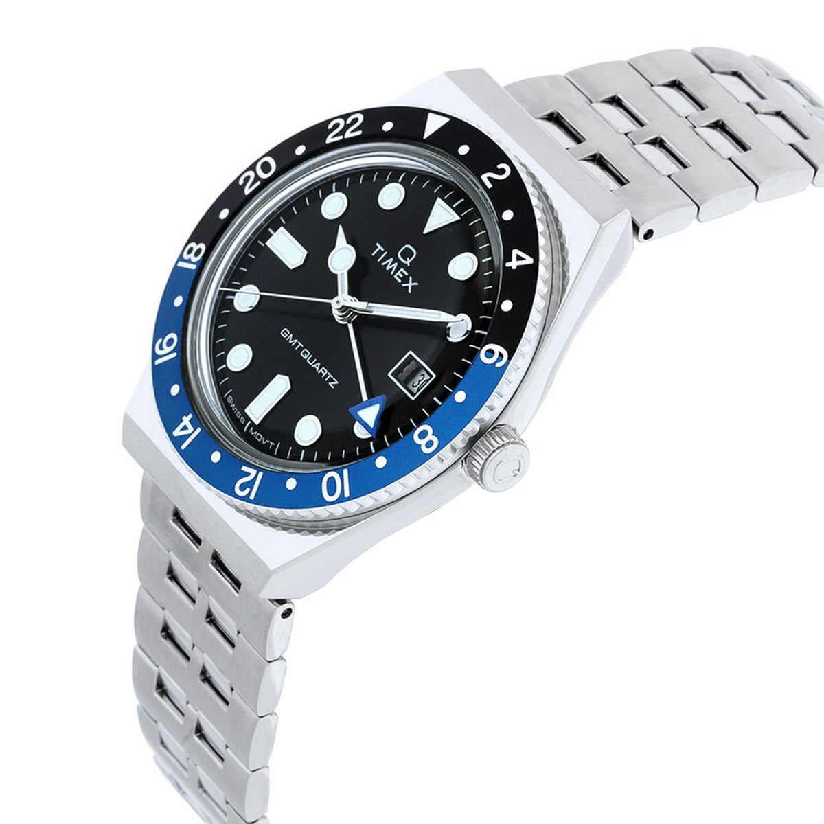 Timex Q Timex GMT TW2V38100 with a black dial, black and blue 24-hour GMT bezel, silver-tone case, crown, date window, and matching silver-tone bracelet.