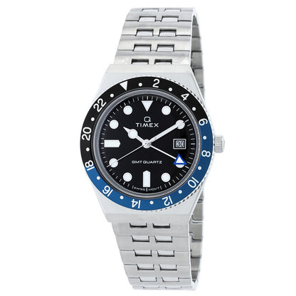 Timex Q Timex GMT TW2V38100 with a black dial, black and blue 24-hour GMT bezel, luminous-style hour markers, date window, silver-tone case, and matching bracelet.