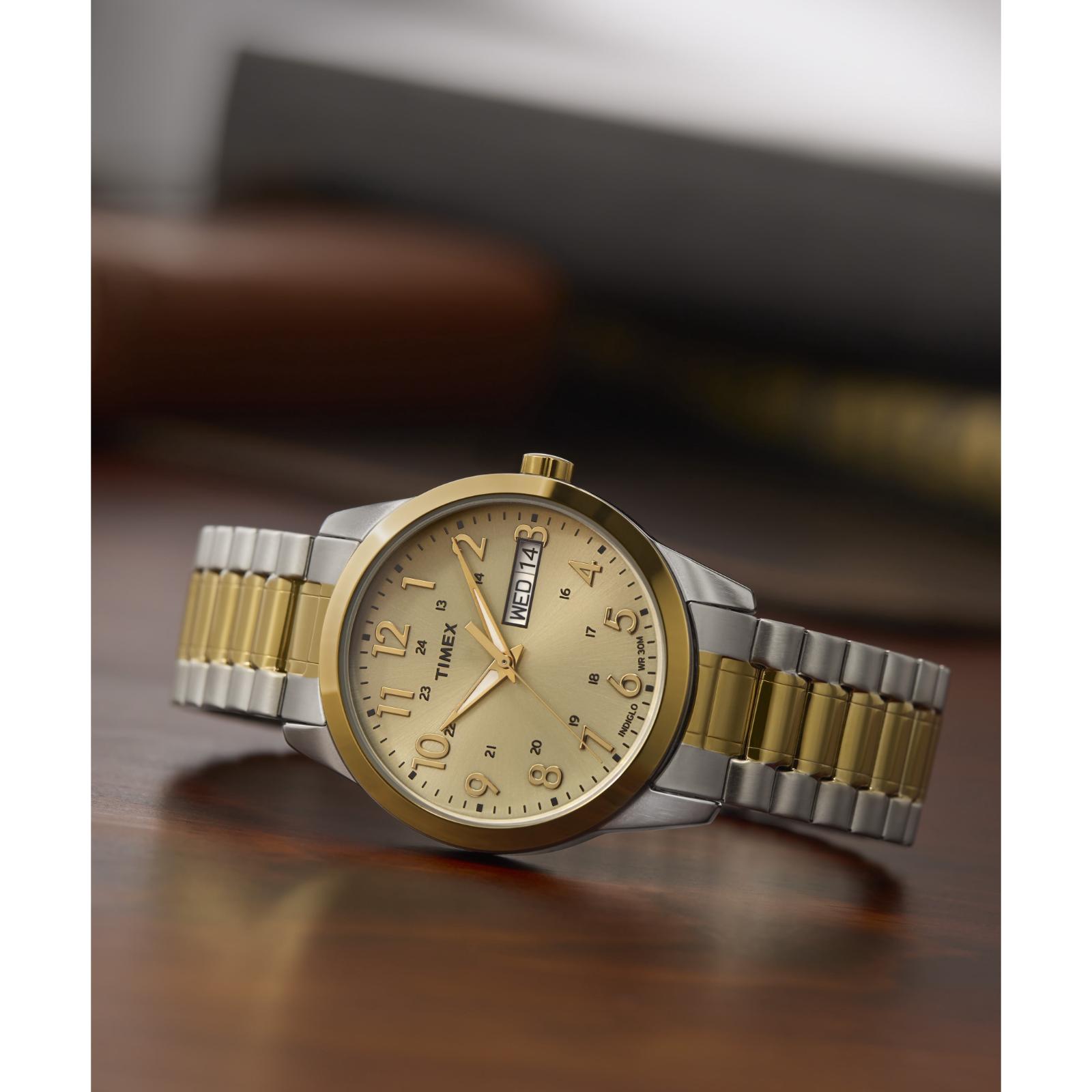 Timex South Street Sport T2M935 day-date watch with champagne dial and two-tone expansion bracelet displayed on a wooden surface.