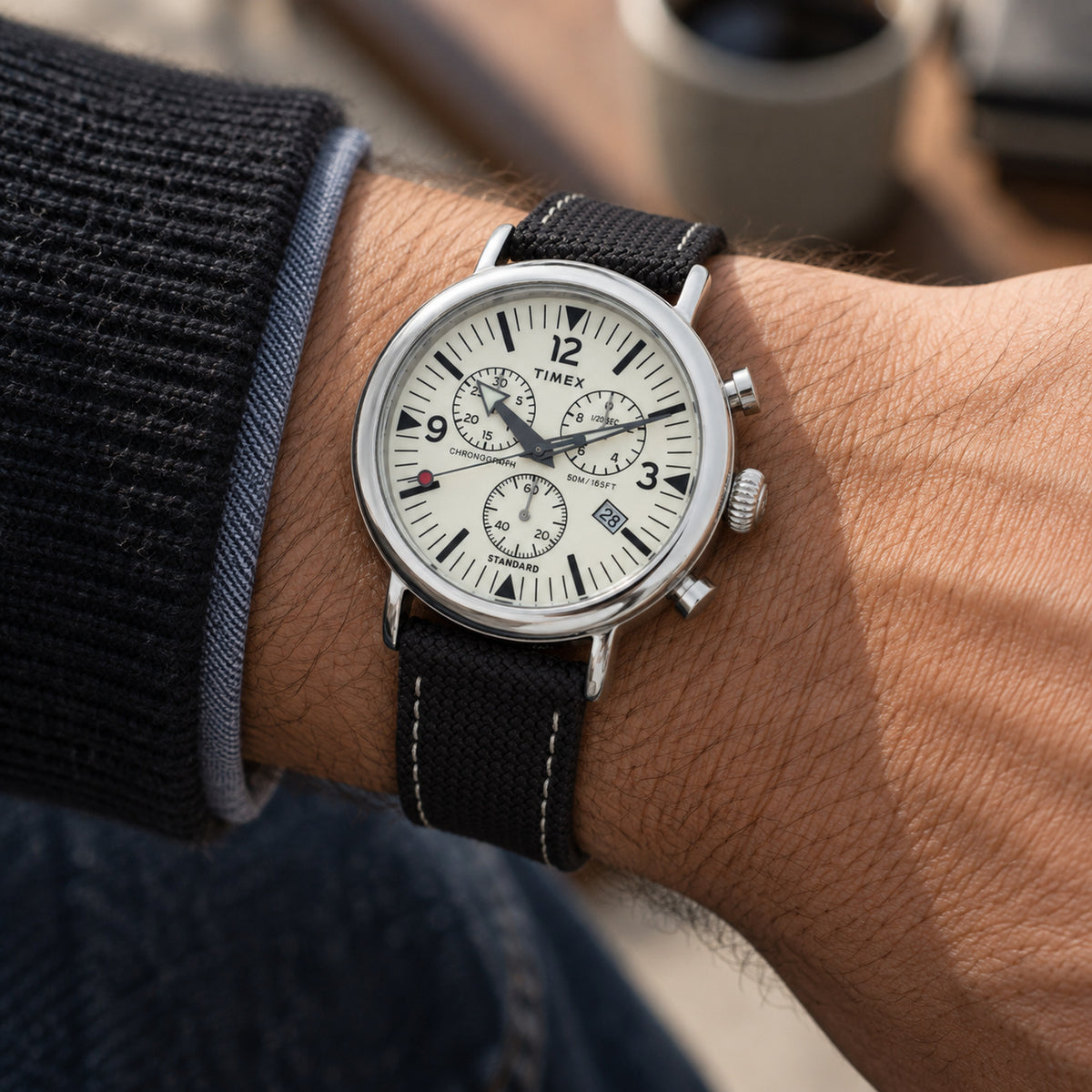 Timex Standard Chronograph TW2V43800 with a cream chronograph dial, black subdials and hour markers, date window, silver-tone case, and black textured strap worn on the wrist.