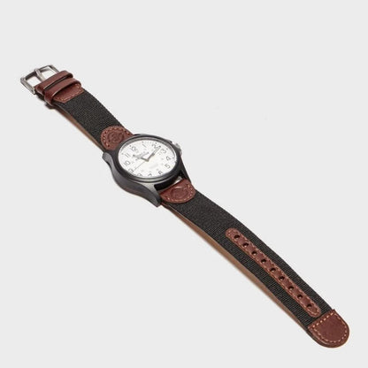 Timex TW4B08200 field watch with white dial, black case and brown leather and fabric strap shown in full view.