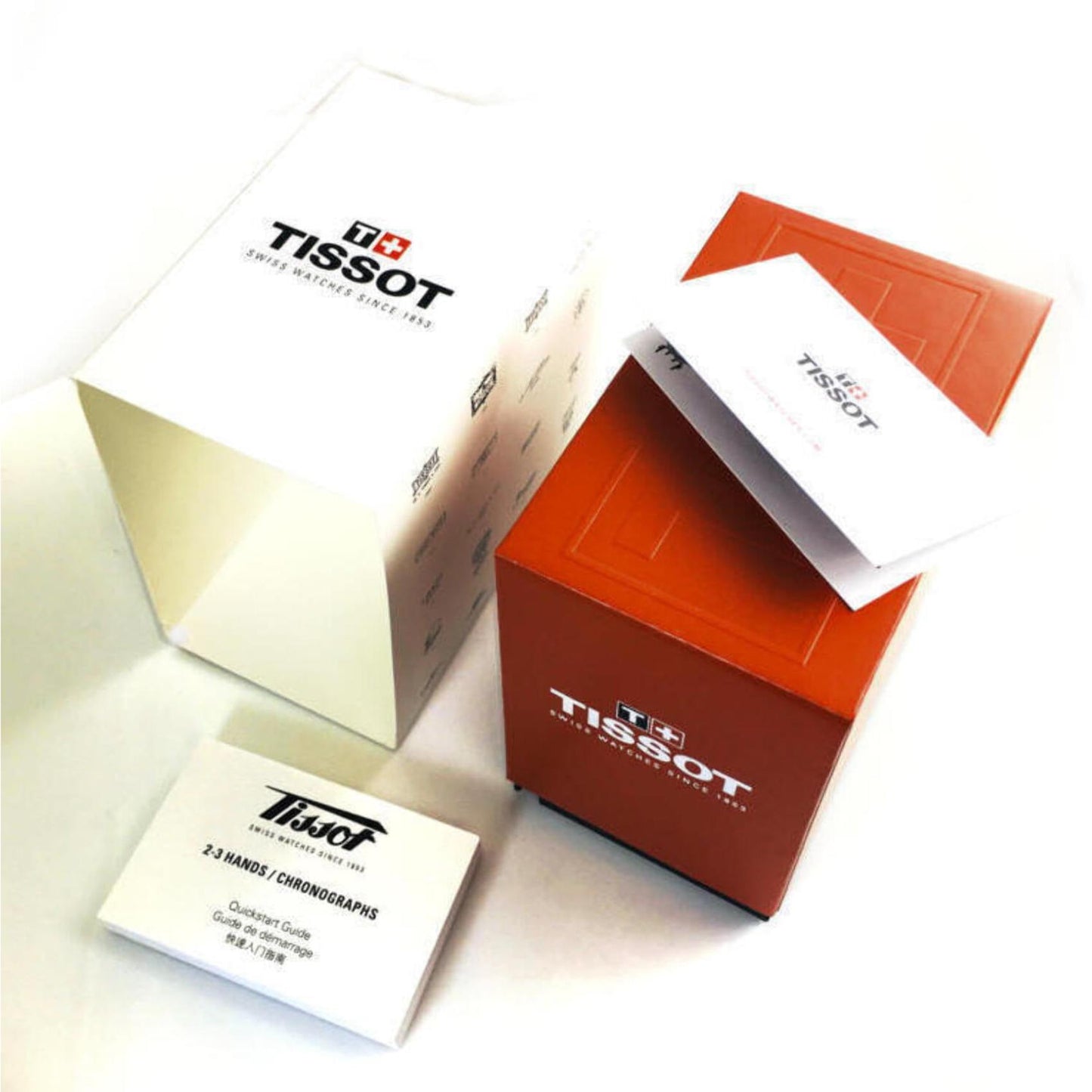 Original Tissot watch packaging set with red presentation box, branded outer sleeve and chronograph instruction manuals.