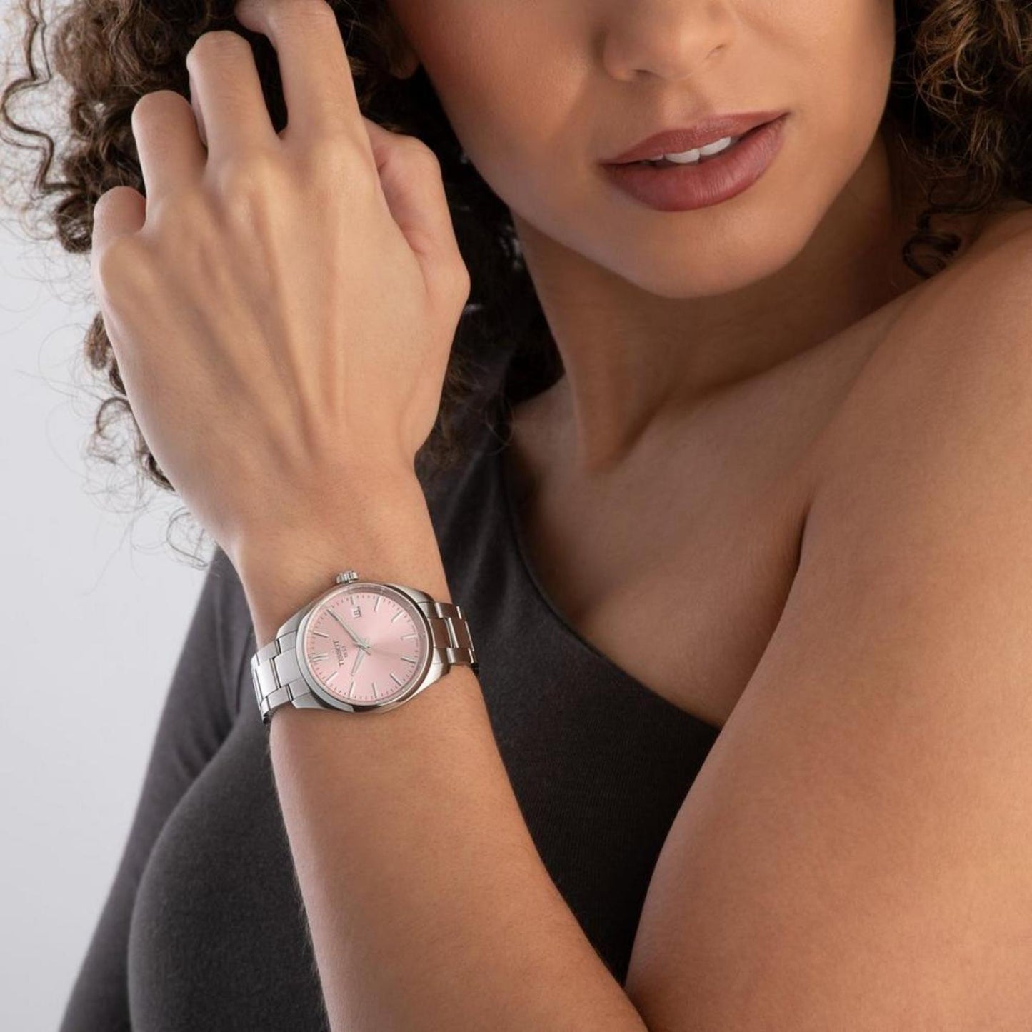 Tissot PR 100 T150.210.11.331.00 with pink sunray dial and stainless steel bracelet worn on the wrist in an elegant everyday style.