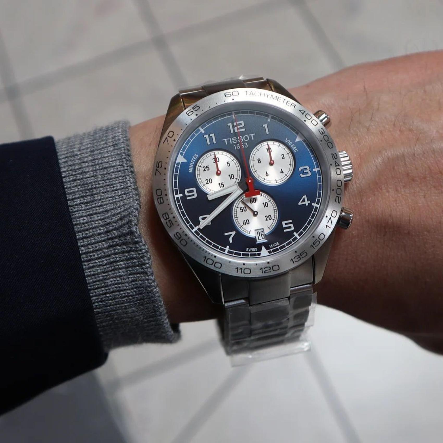 Tissot PRS 516 Chronograph T131.617.11.042.00 Swiss sport watch worn on wrist with blue dial, tachymeter bezel, chronograph subdials and stainless steel bracelet.