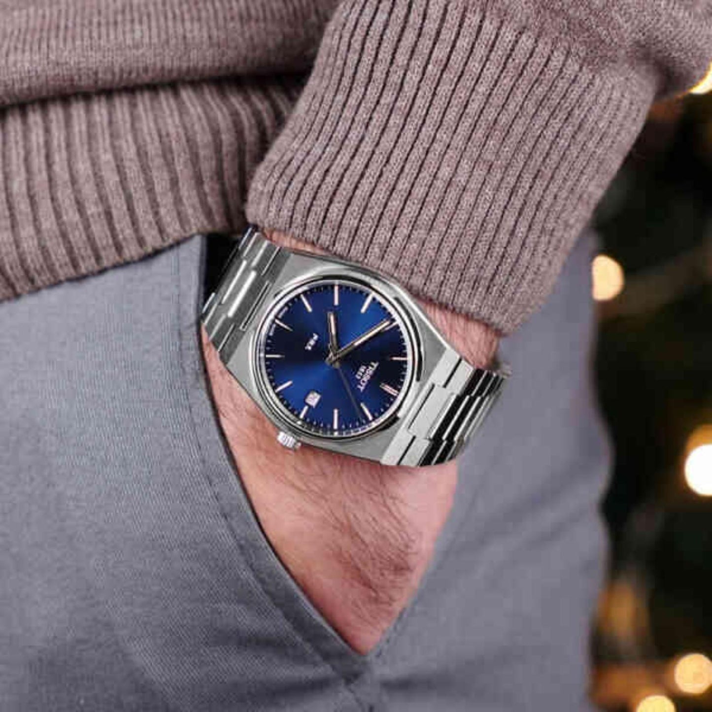 Tissot PRX T137.210.11.041.00 with blue sunray dial, integrated stainless steel bracelet, and slim silver-tone case worn on the wrist in a casual modern style.