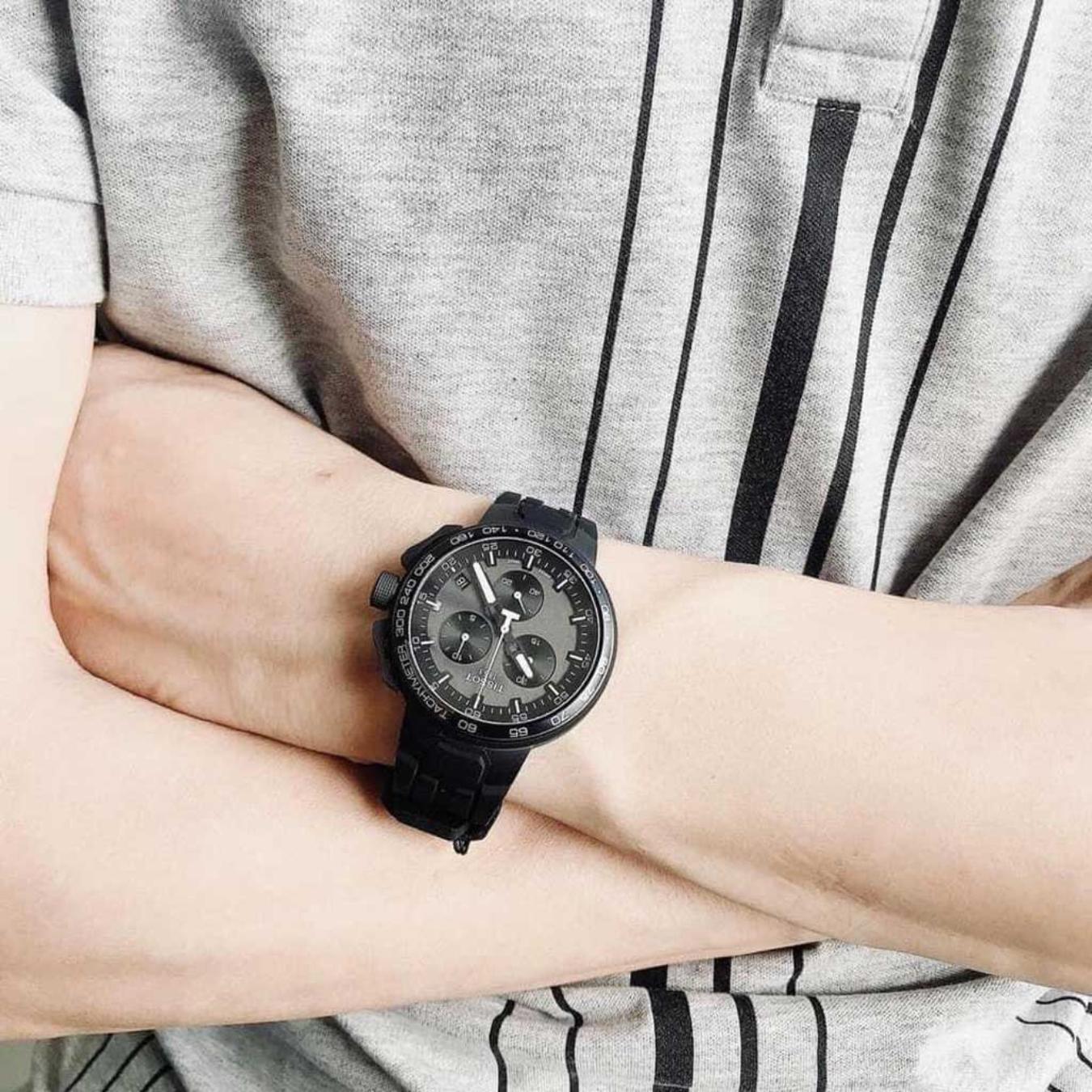 Tissot T111.417.37.441.03 chronograph watch worn on the wrist with black dial, subdials and black silicone strap.