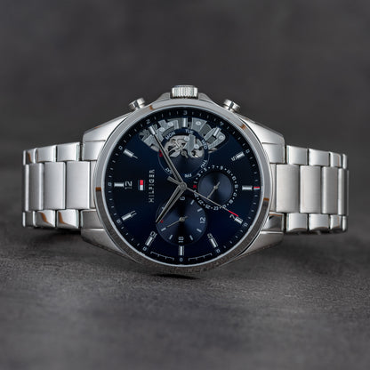 Tommy Hilfiger 1791348 chronograph watch with blue dial, subdials and stainless steel bracelet shown in close-up.