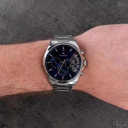 Tommy Hilfiger 1791348 chronograph watch worn on the wrist with blue dial, subdials and stainless steel bracelet.