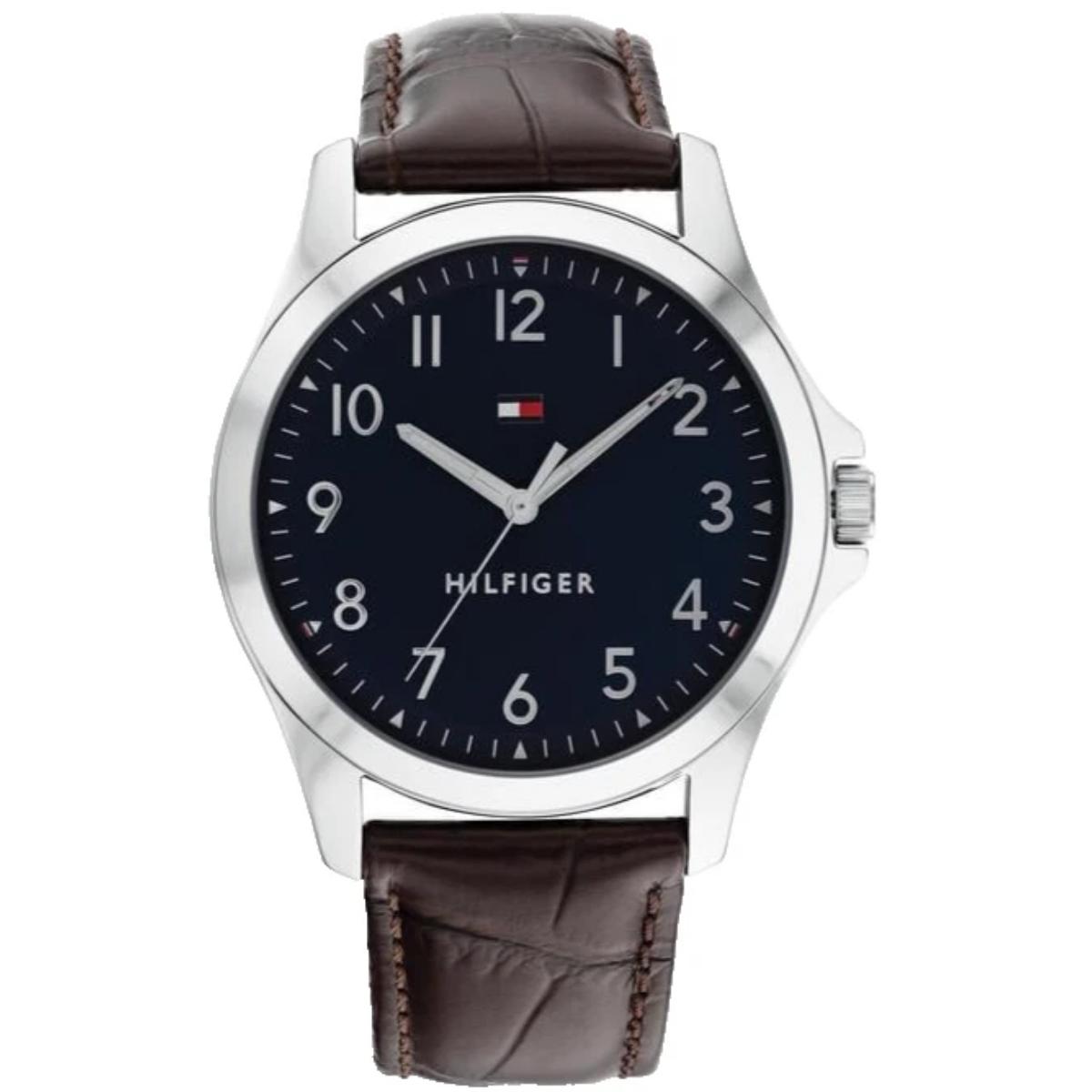 Tommy Hilfiger 1791449 men’s watch with navy blue dial, silver-tone case, minimalist numeral markers, and brown leather strap.