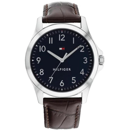 Tommy Hilfiger 1791449 men’s watch with navy blue dial, silver-tone case, minimalist numeral markers, and brown leather strap.