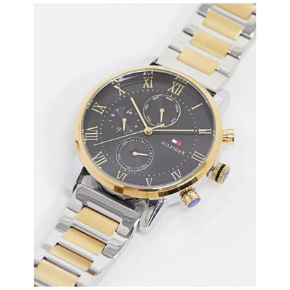 Tommy Hilfiger 1791539 chronograph watch with black dial, subdials, gold-tone bezel and two-tone stainless steel bracelet shown at an angle.