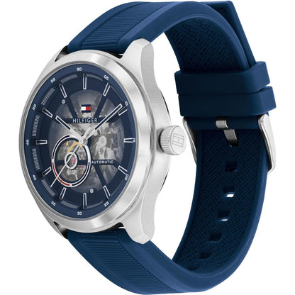 Tommy Hilfiger 1791885 men’s automatic watch with blue skeleton dial, silver-tone case, and textured blue silicone strap shown in an angled view.