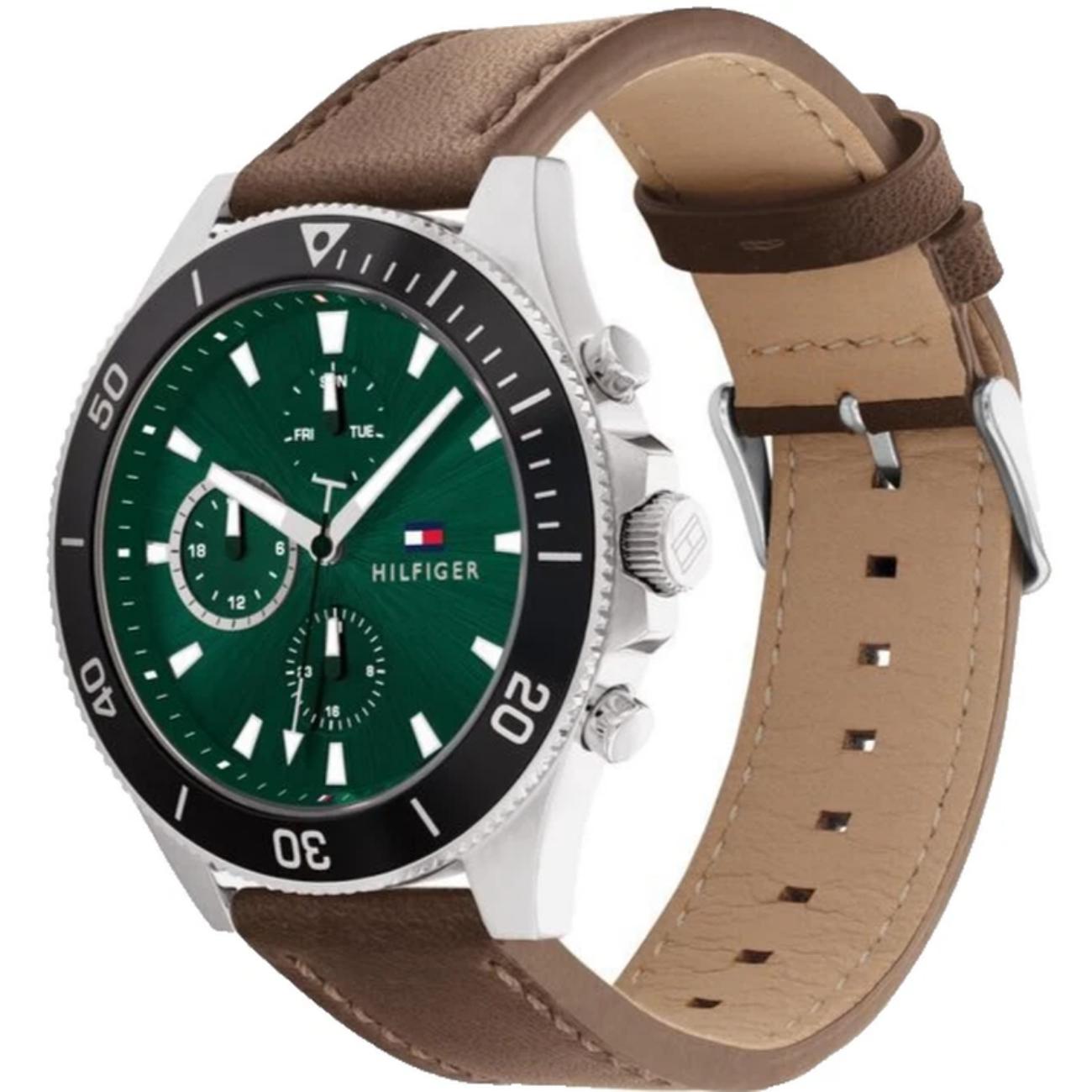 Tommy Hilfiger 1791983 men’s multifunction watch with green dial, black bezel, silver-tone case, and brown leather strap shown in an angled view.