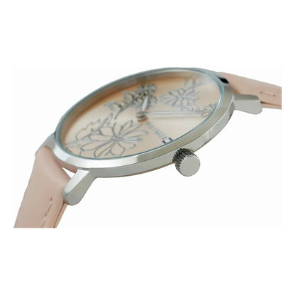 reloj Tommy Hilfiger visto de perfil con caja metálica delgada, corona lateral y correa rosa clara fijada a las asas