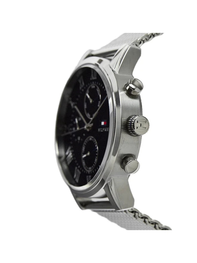 Reloj Tommy Hilfiger plateado con correa mesh visto de perfil mostrando corona y pulsadores laterales