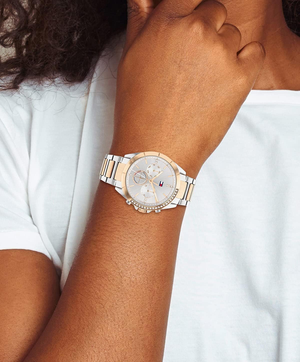 Reloj Tommy Hilfiger bicolor para mujer con esfera clara y bisel decorado, mostrado en la muñeca en una imagen de estilo lifestyle.